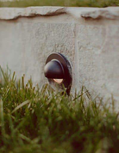 Closeup photo of garden light in pale stone retaining wall